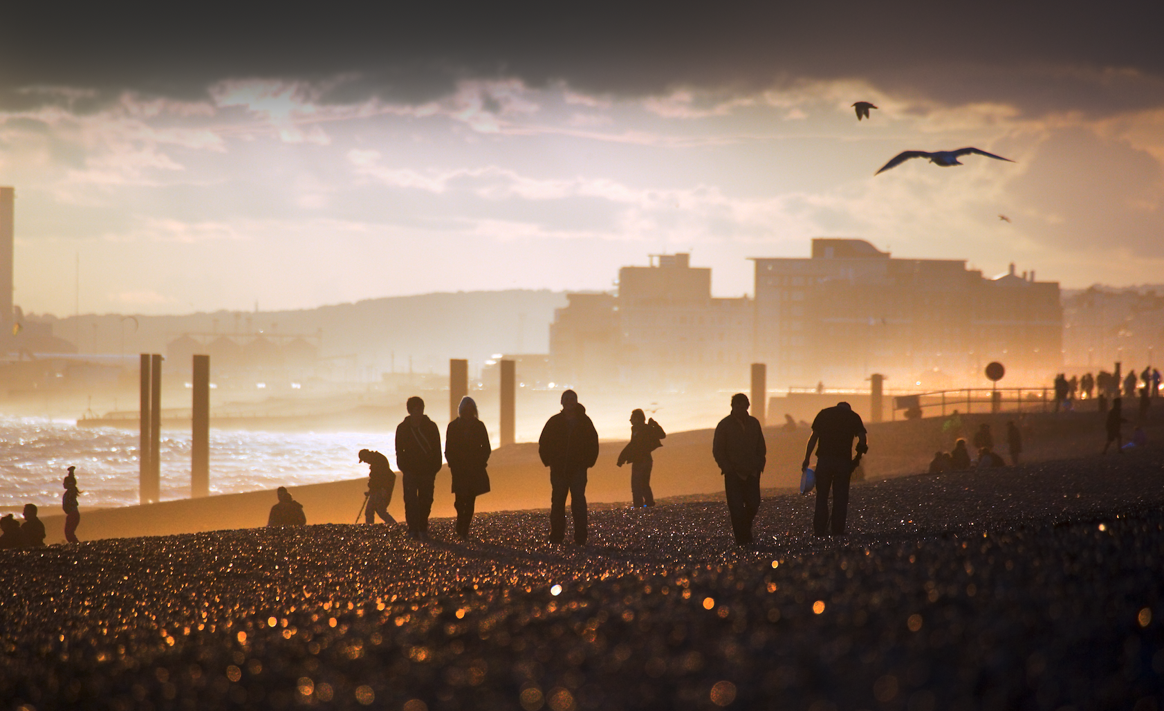 People walking on a beach at sunset